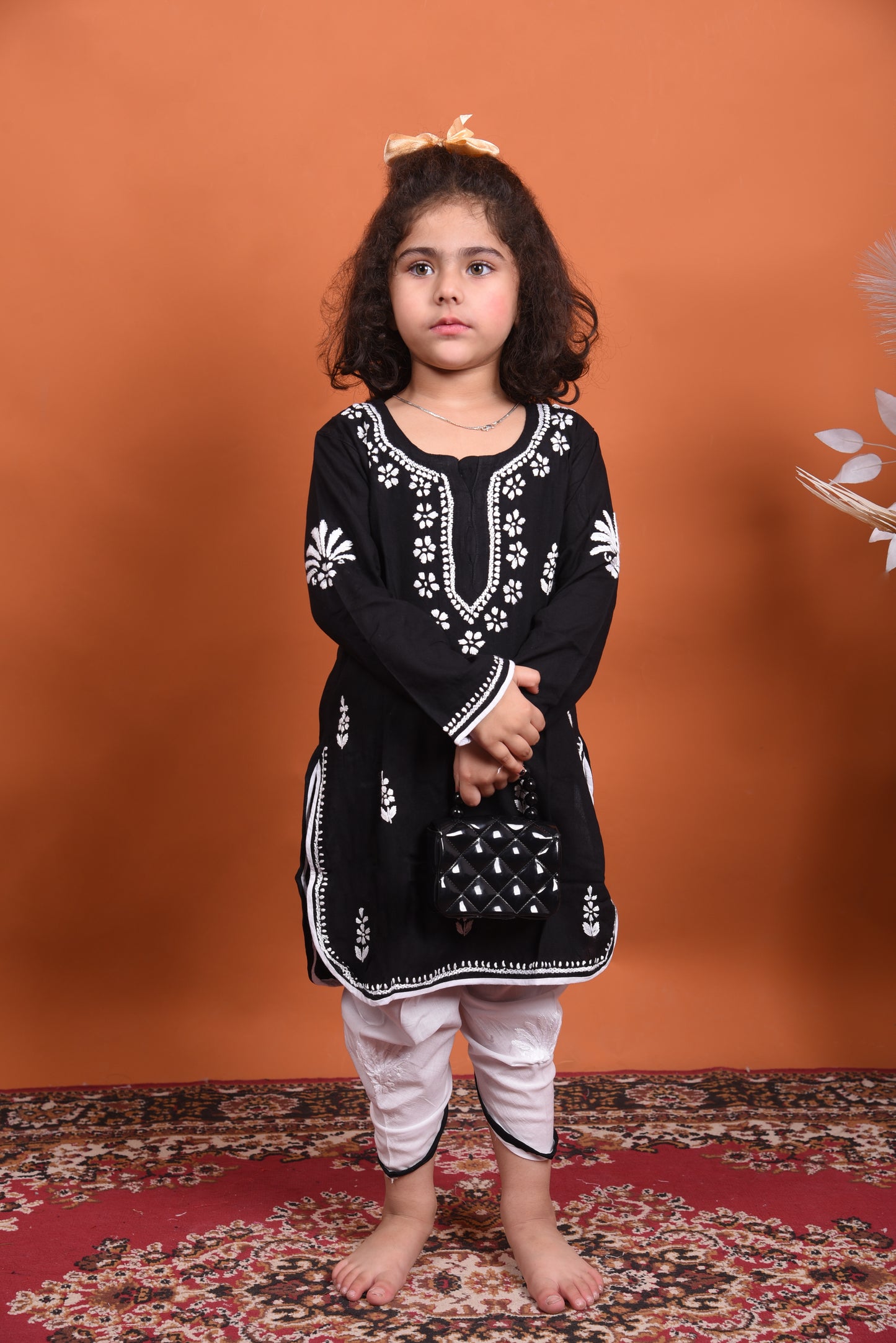Young girl wearing a black embroidered kurta with white dhoti
