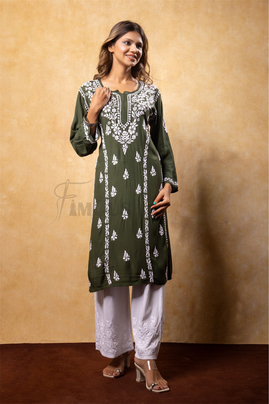 Woman wearing a green embroidered kurta with white pants against a beige background
