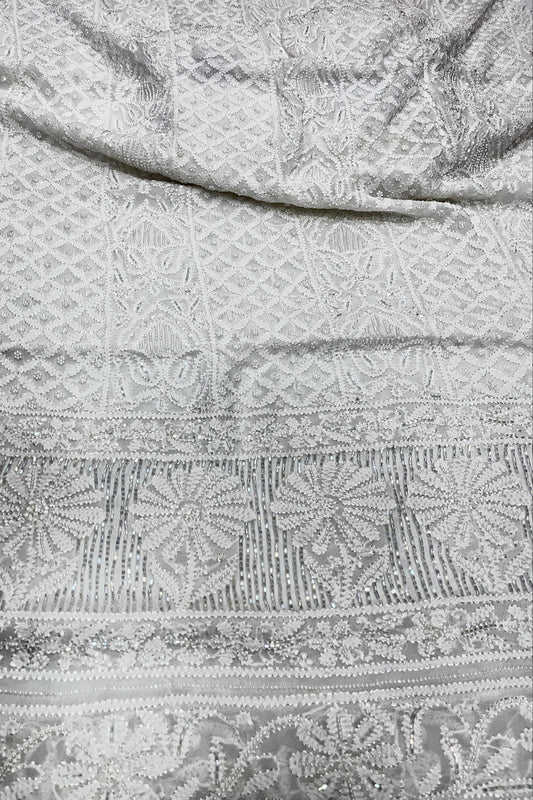 Close-up of a textured fabric with intricate patterns in gray and white.