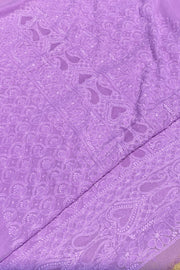 A close-up of a lavender purple fabric with intricate floral and paisley embroidery, showing the texture and pattern details.