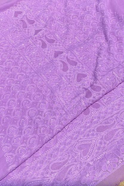 A close-up of a lavender purple fabric with intricate floral and paisley embroidery, showing the texture and pattern details.