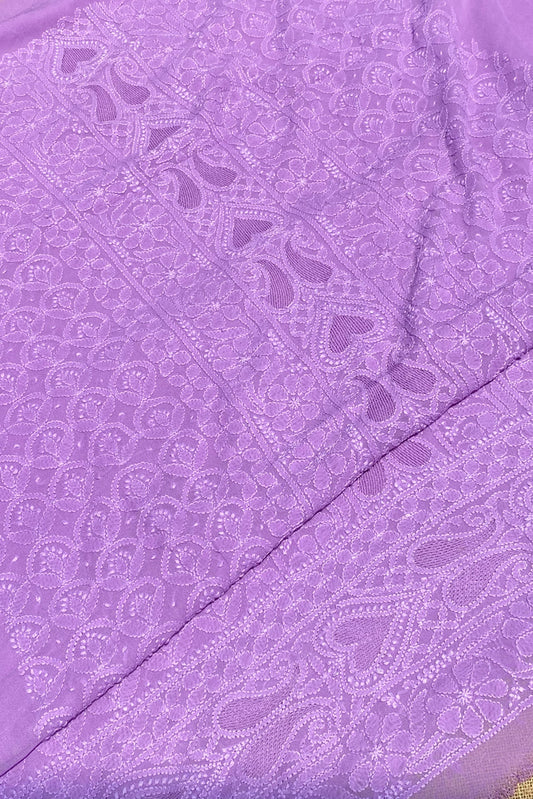 A close-up of a lavender purple fabric with intricate floral and paisley embroidery, showing the texture and pattern details.