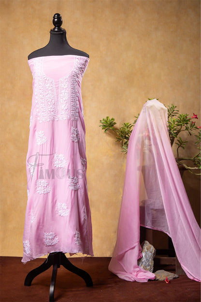 Pink embroidered dress on a mannequin with a matching dupatta draped over it against a beige background.