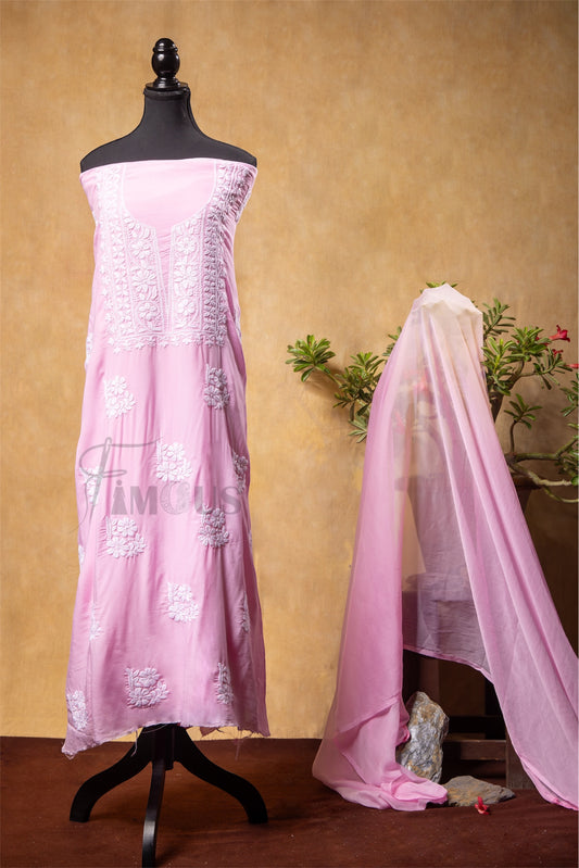 Pink embroidered dress on a mannequin with a matching dupatta draped over it against a beige background.