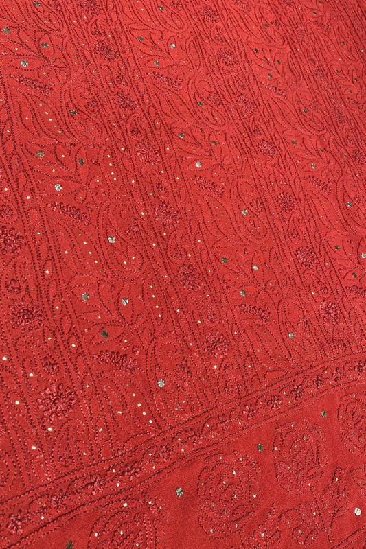 Close-up of a red fabric with intricate patterns and embellishments
