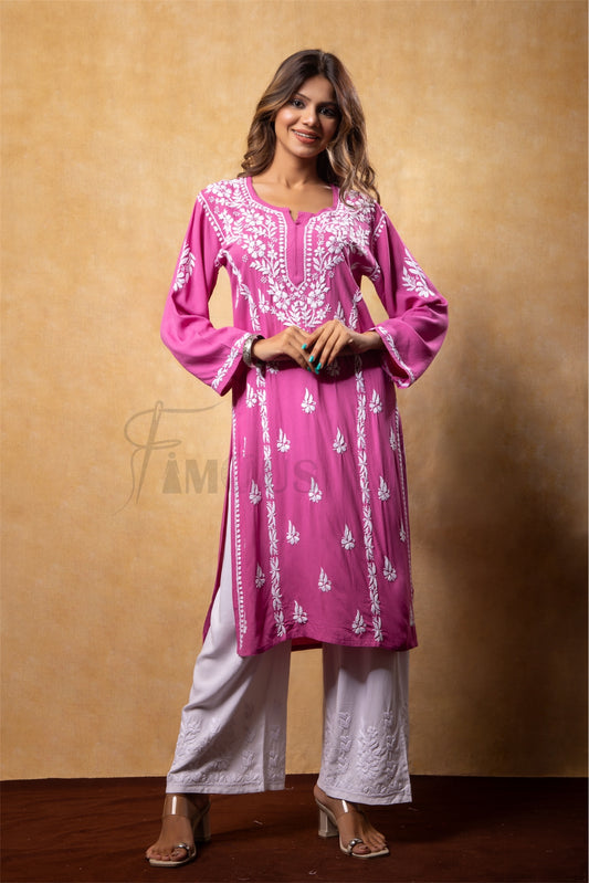 Woman wearing a pink embroidered kurta with white pants against a beige background