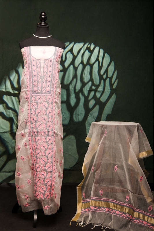 Traditional embroidered dress on a mannequin with a sheer dupatta beside it against a dark background.